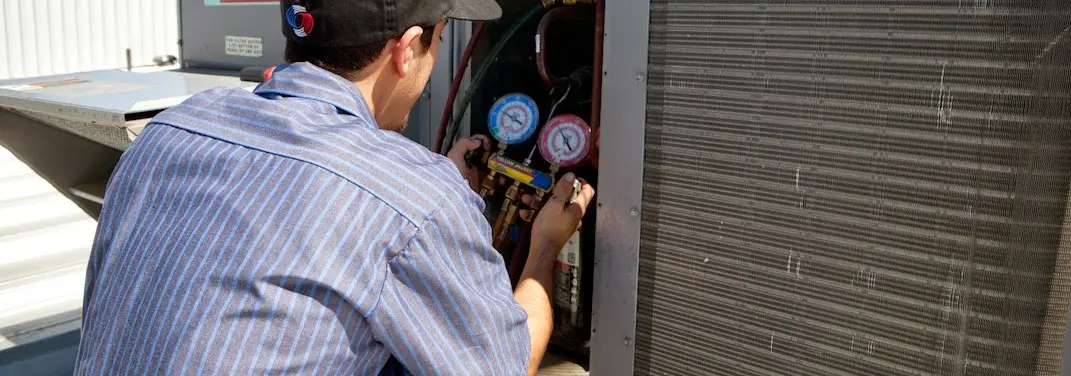 HVAC technician servicing a condenser unit in Wenatchee