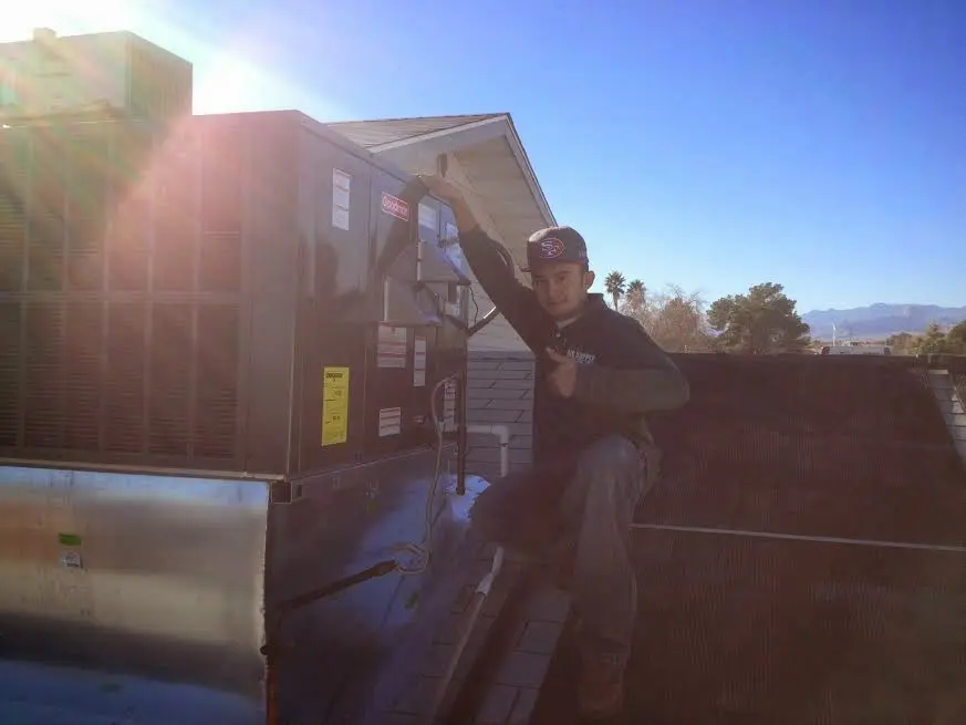 HVAC technician performing Heat Pump Repair on a rooftop unit in Wenatchee